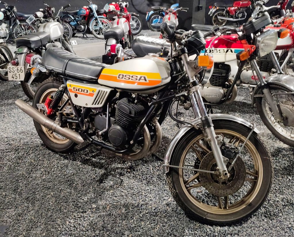 orange and white motorbike with other motorbikes behind it